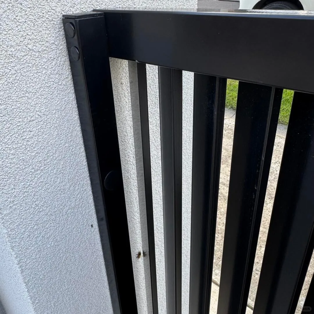 Metal frame connection beside a rendered wall pillar